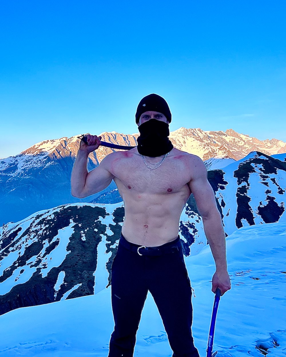 Sébastien Caron torse nu, musclé et sec, au sommet d’une montagne enneigée